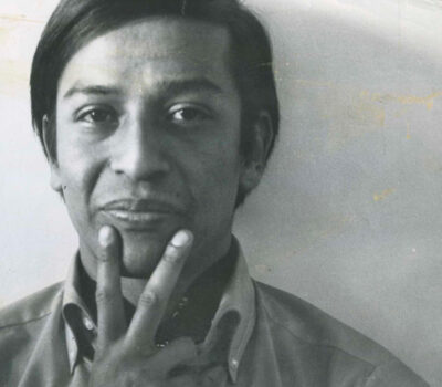 Foto de José Agustín levantando dos dedos haciendo el símbolo de la paz